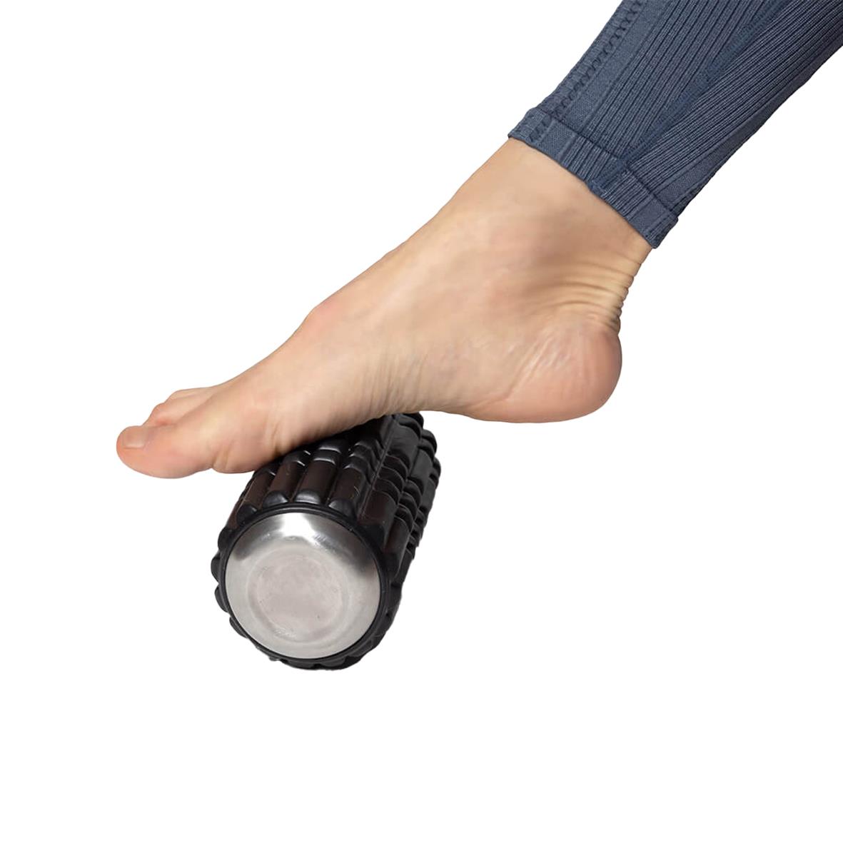 Fot på en fot som använder en svart Wavewell foam roller för muskelmassage