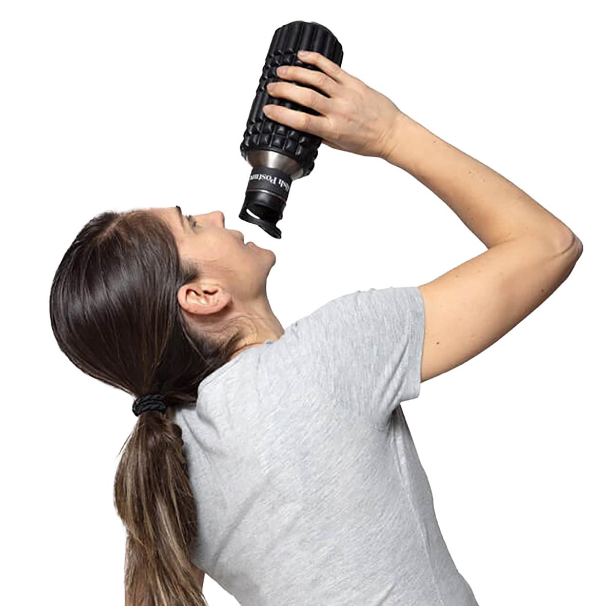 Kvinna dricker vatten från en svart vattenflaska, använder en Wavewell foam roller för postural träning