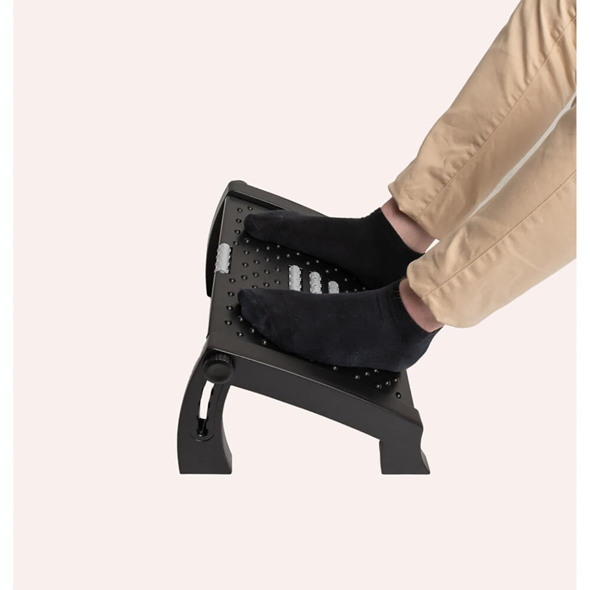 Fotstöd för ergonomisk fotpositionering med person som använder svart socka och beige byxor