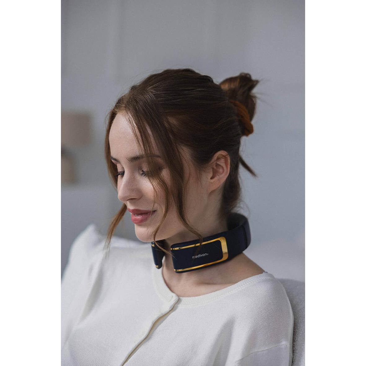 Kvinna använder nackmassageapparat Medivon Ultra EMS Pro runt halsen