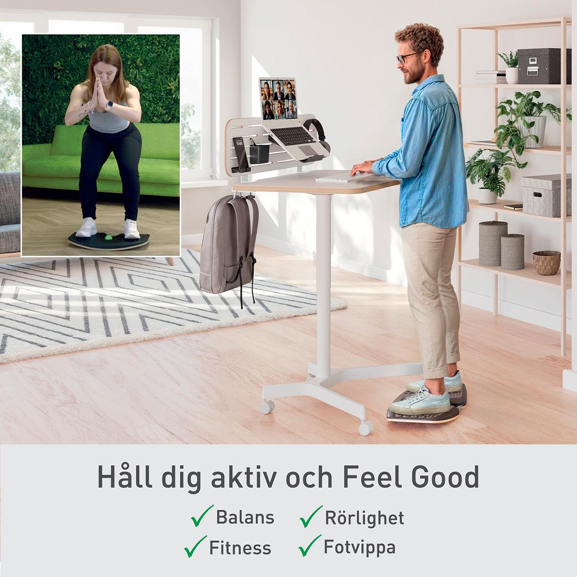 Man står på en balansbräda framför en dator, inomhus, med en bild av en kvinna som tränar hemma i ett fönster.