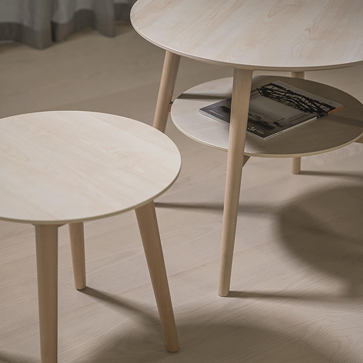 Två runda träbord i ljus färg, ett mindre och ett större, med en hylla under det större bordet