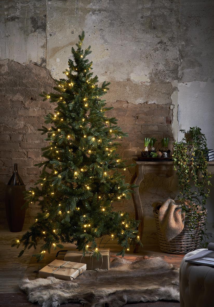 Julgran i Larvik med 270 LED-lampor, 180 cm hög, i ett rum med vägg i tegel och dekorationer