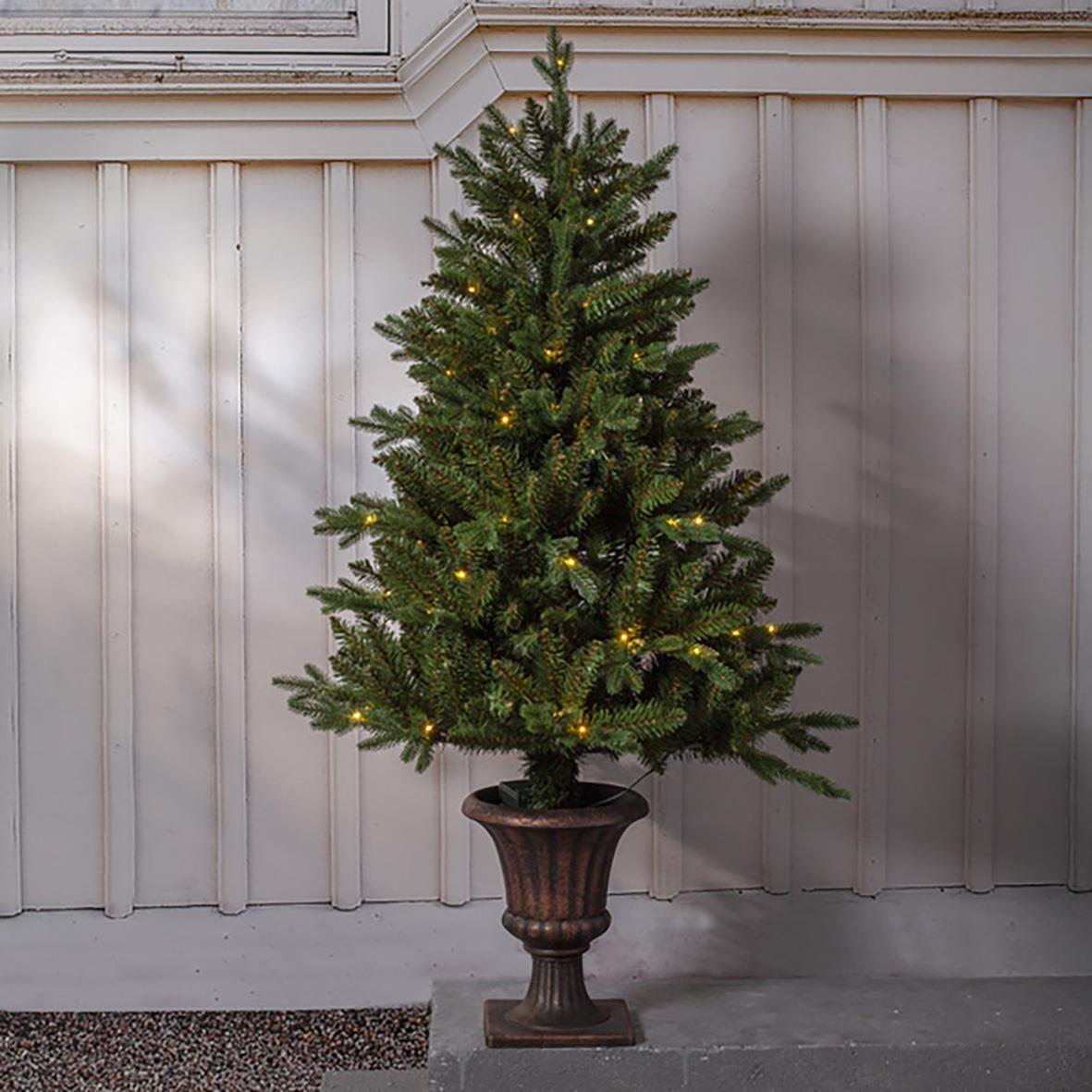 Julgran i kruka med 80 LED-lampor, 120 cm hög, placerad framför vit trävägg