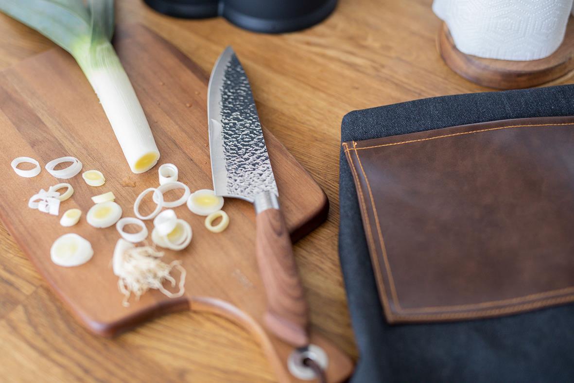 Knivset Dorre Akira med flera knivar och skärbräda på träbord