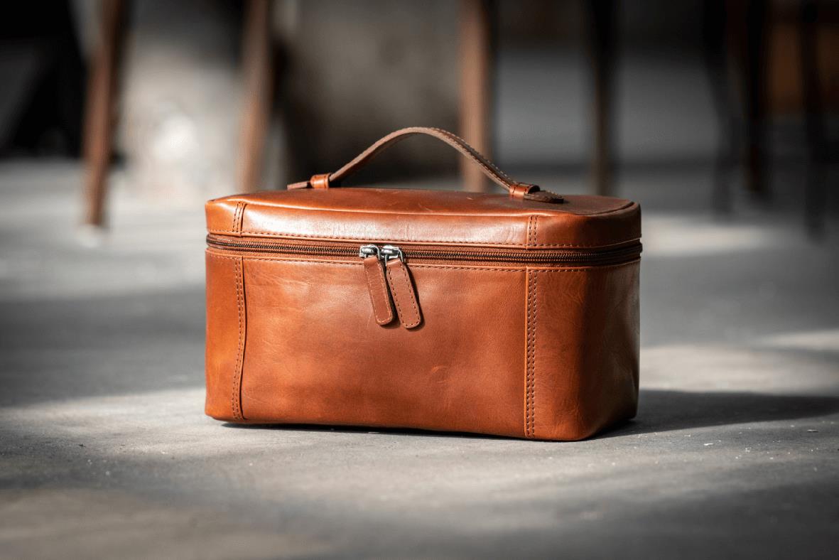 Cognacfärgad necessär i skinn med handtag och dragkedja