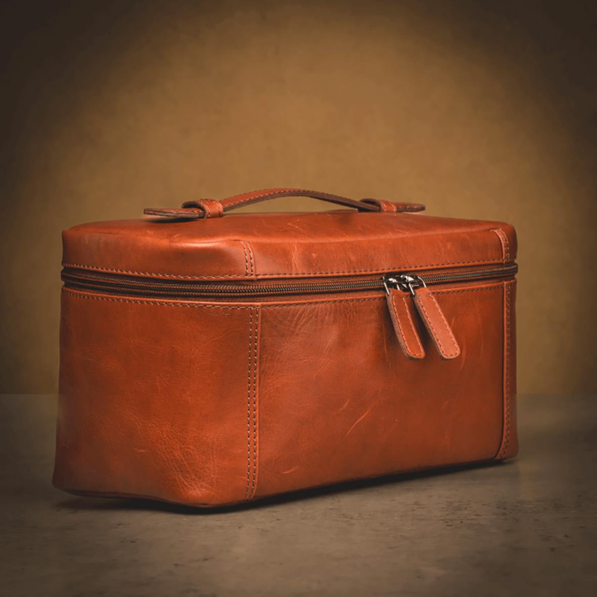 Necessär i skinn i färgen cognac med dragkedja och handtag