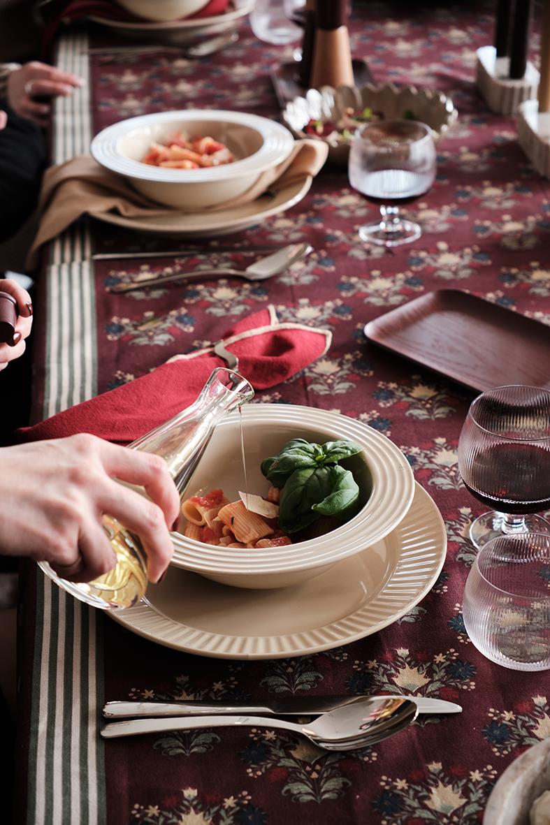 Olja- eller vinägerflaska på ett dukat bord med mat och glas, Sagaform Gurken