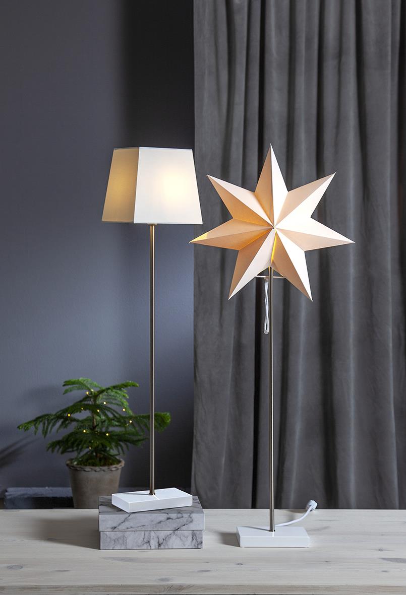 Kombistjärna Star Trading med skärm och stjärna Moa på bord framför grå gardiner och växt