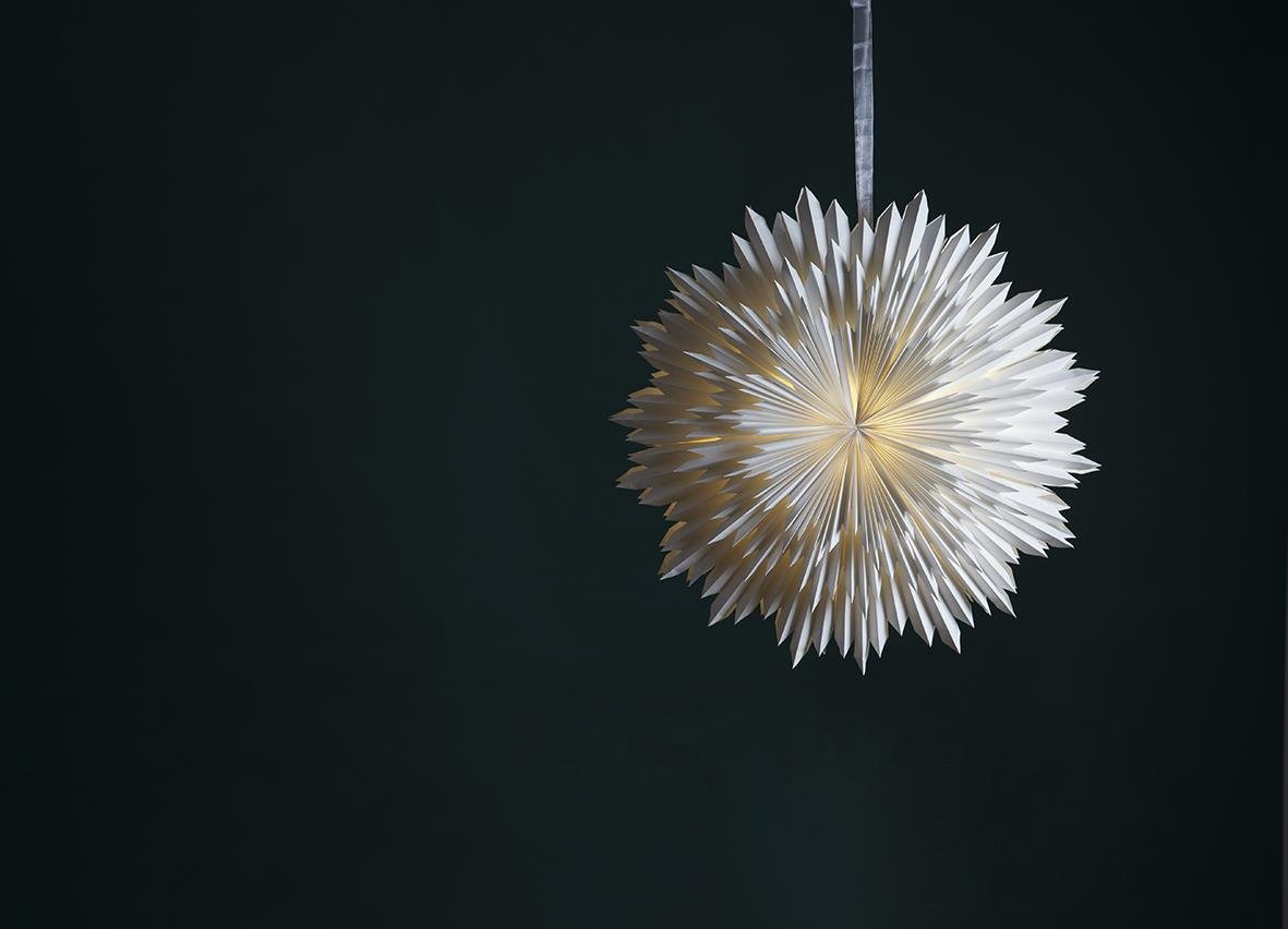 Vit julstjärna i form av en snöflinga, 70 cm lång, hängande mot mörk bakgrund