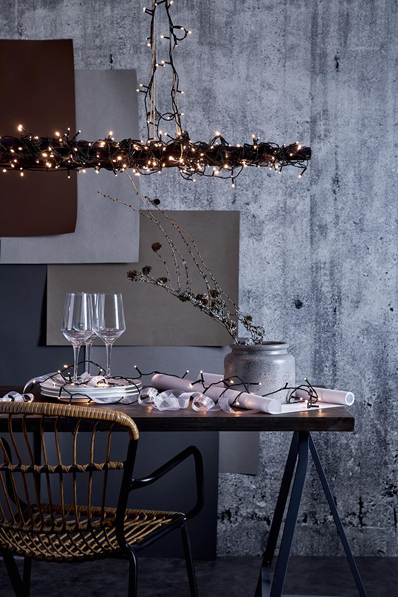 Ljusslinga Crispy Ice White 40 LED lampor hängande över ett bord med glas och servetter, mot en grå vägg