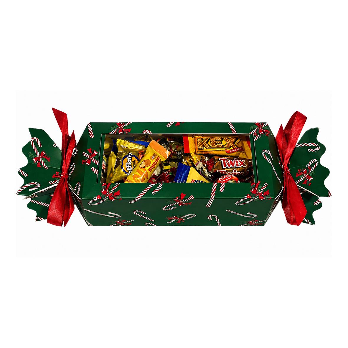 Julgodis i en presentlåda med grönt papper och röda band