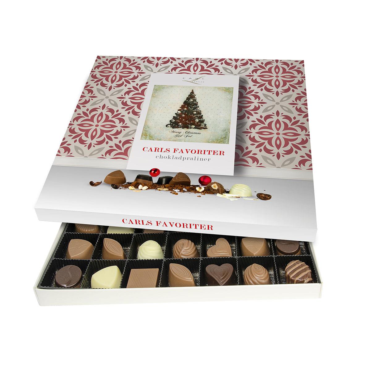 Öppen chokladask med Carls Favoriter praliner och julmotiv på förpackningen
