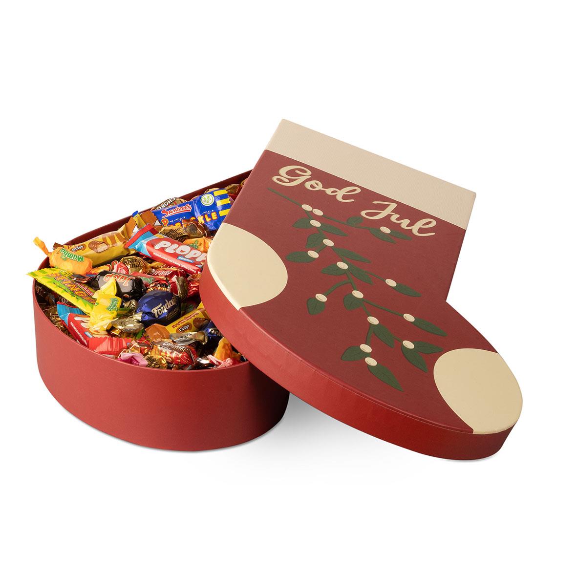 Röd julstrumpa fylld med chokladgodis och en julhälsning