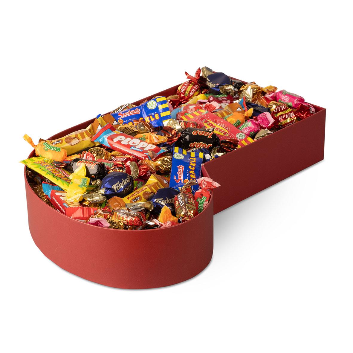 Julstrumpa fylld med olika chokladgodisar i en röd låda