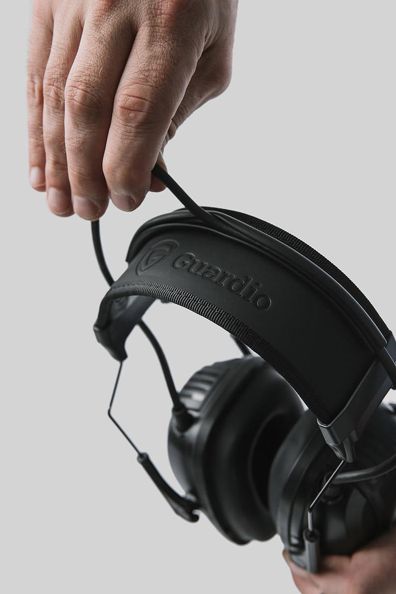 Person som håller i en svart hörselkåpa Guardio Freebird COM One Size