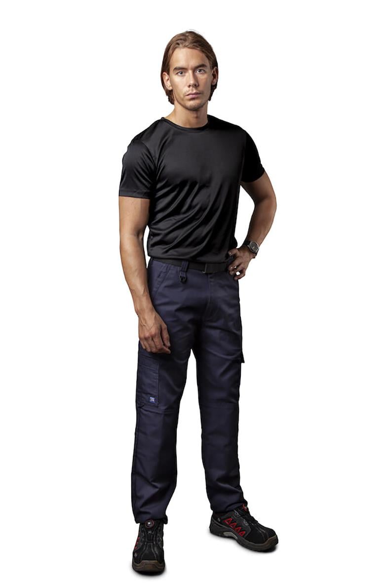 Man i svart T-shirt och mörka arbetsbyxor står med hand i fickan