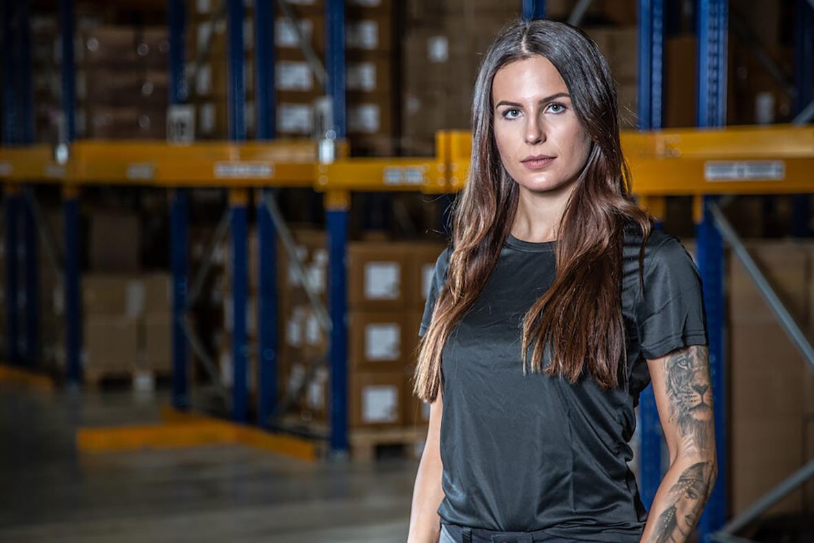 Kvinna i svart T-shirt i lagermiljö