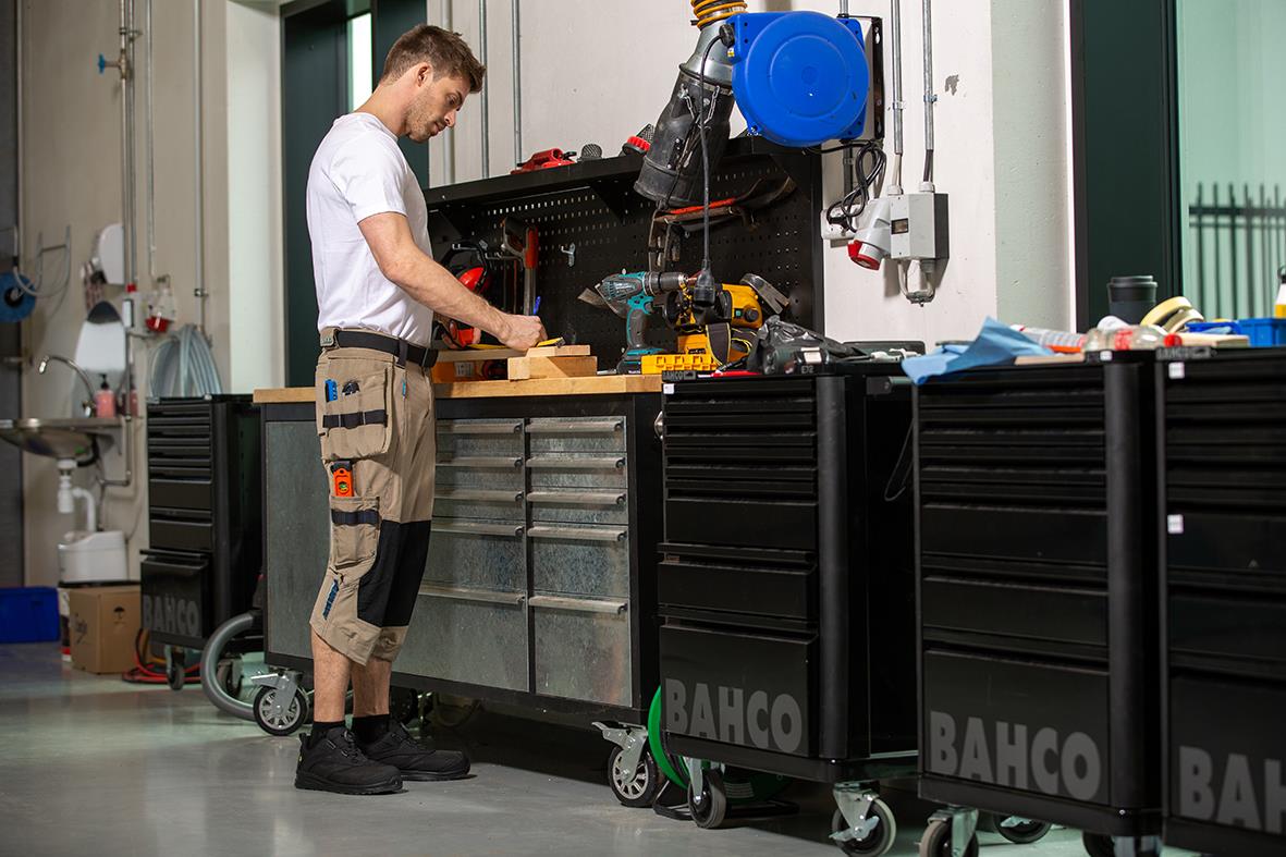 Man arbetar i verkstad med verktyg och utrustning på arbetsbänk