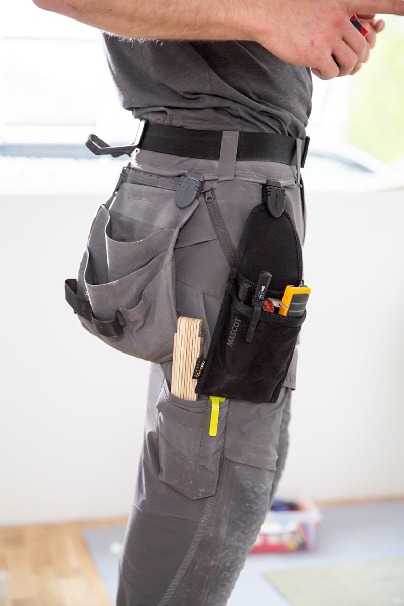 Svart hängficka med verktyg och pennor, bärs på höften