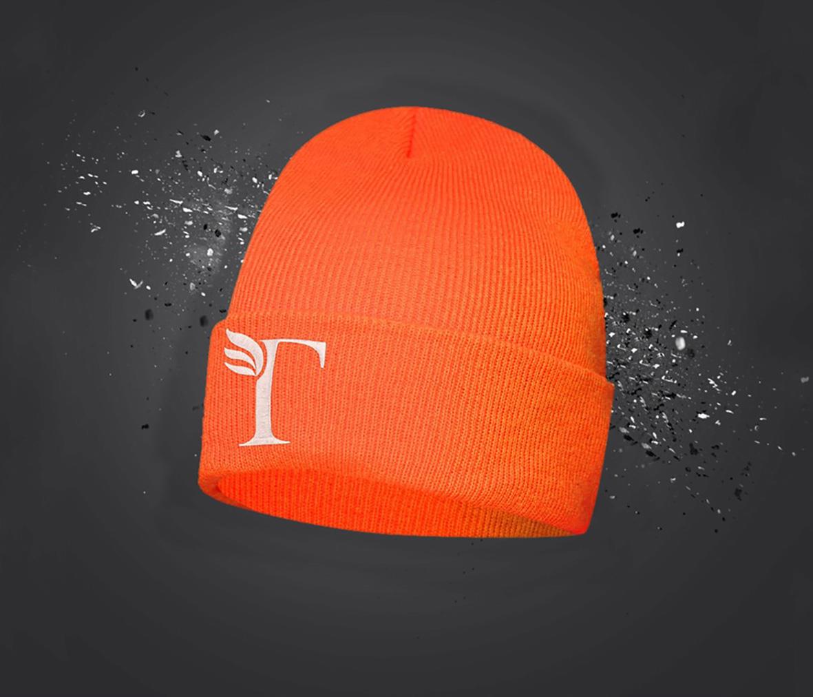 Orange mössa med vit T-logga och svart bakgrund med splattereffekt