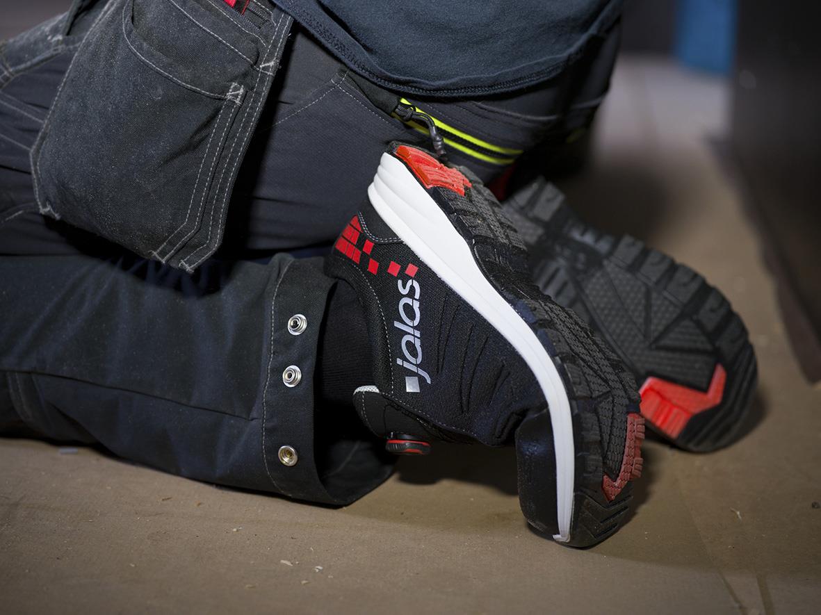 Skyddssko Jalas 7138 Zenit Evo Easyroll i svart med röda detaljer, person knästående på golv