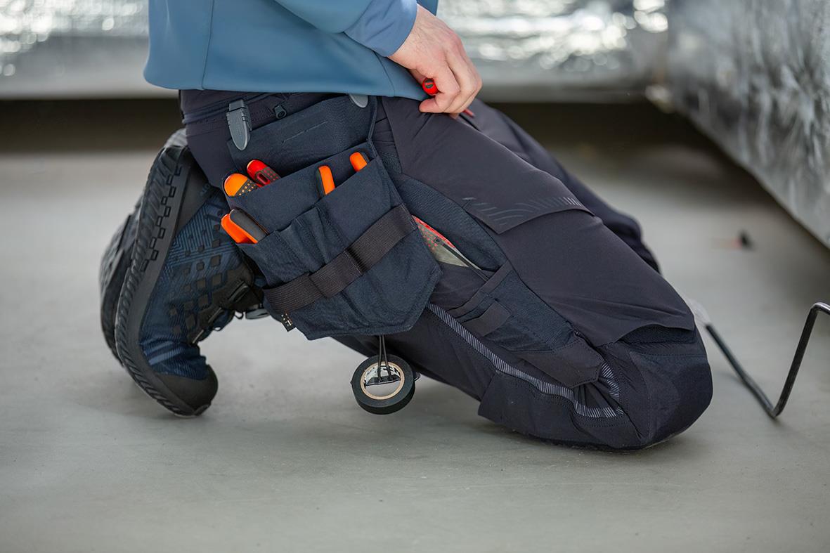 Skyddssko Mascot F0650-704 S1P BOA i stenblå/svart, person på knä med verktygspåse