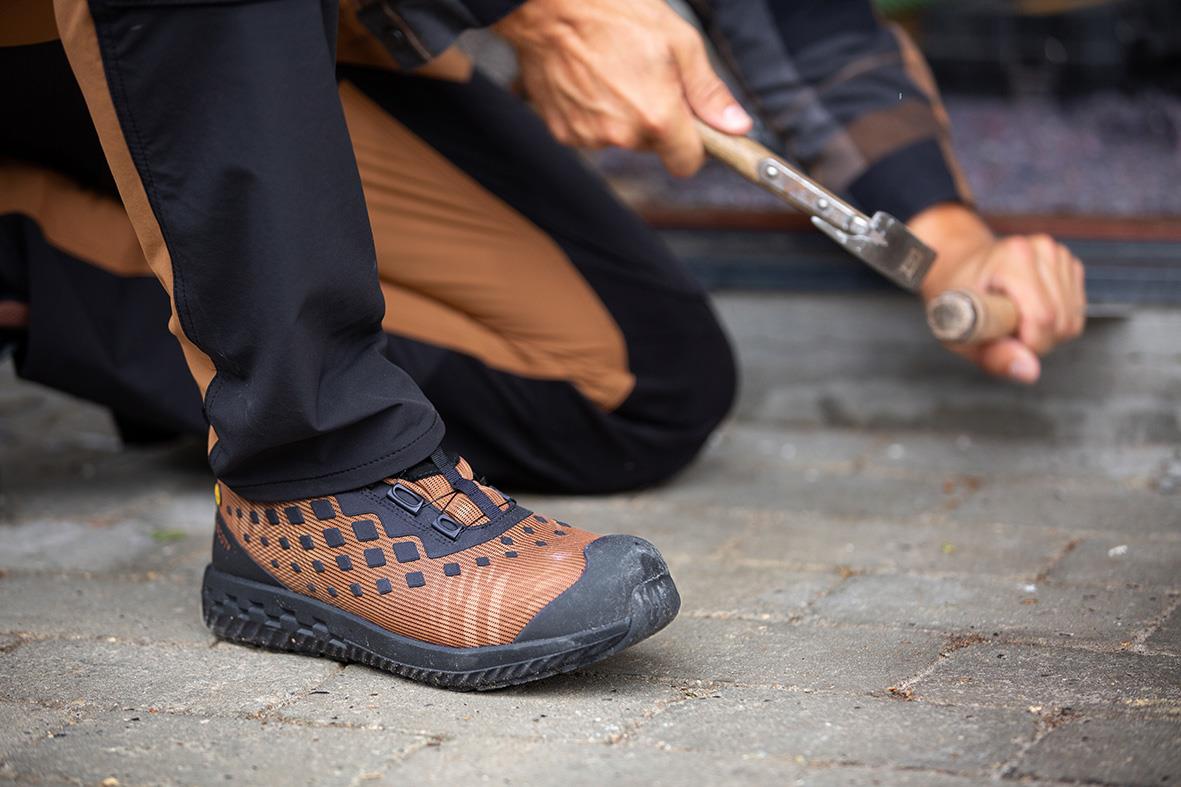 Skyddssko Mascot F0650-704 S1P BOA Nötbrun/Svart 36 på person som arbetar med att spika på golv