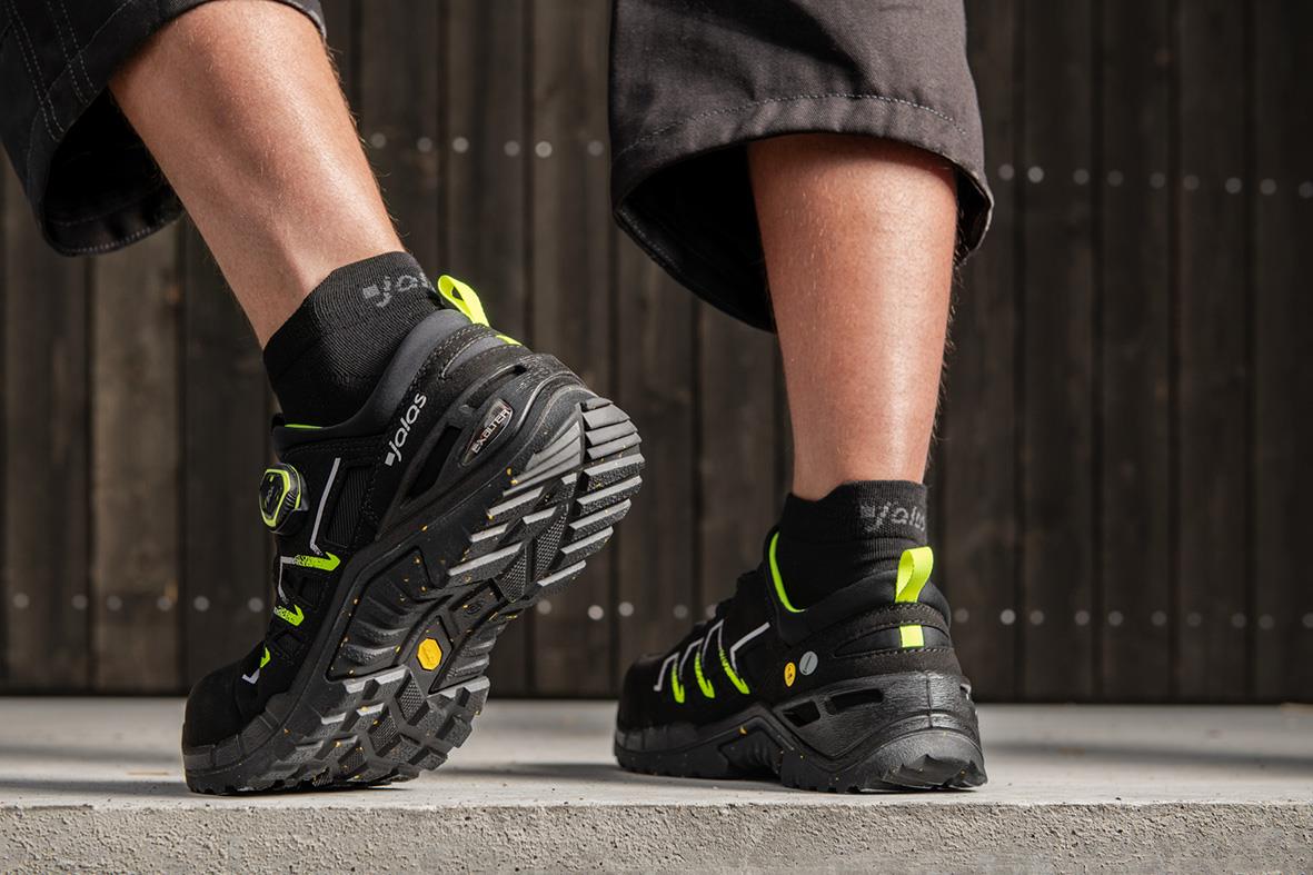 Skyddssko Jalas 9935 i svart med gröna detaljer, person står på betong