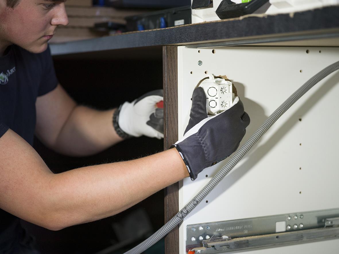 Person som installerar en montagehandske Tegera 114 Getnarv 7 på en vägg