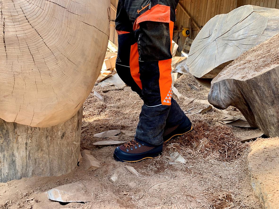 Person som bär sågskyddskänga Jalas 1988 GTX 40 på en träig yta