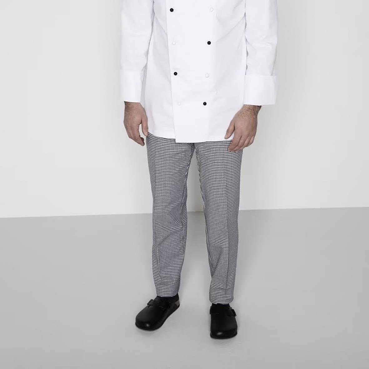 Person i vit labbrock och rutiga byxor som bär svarta Birkenstock Boston SL sandaler