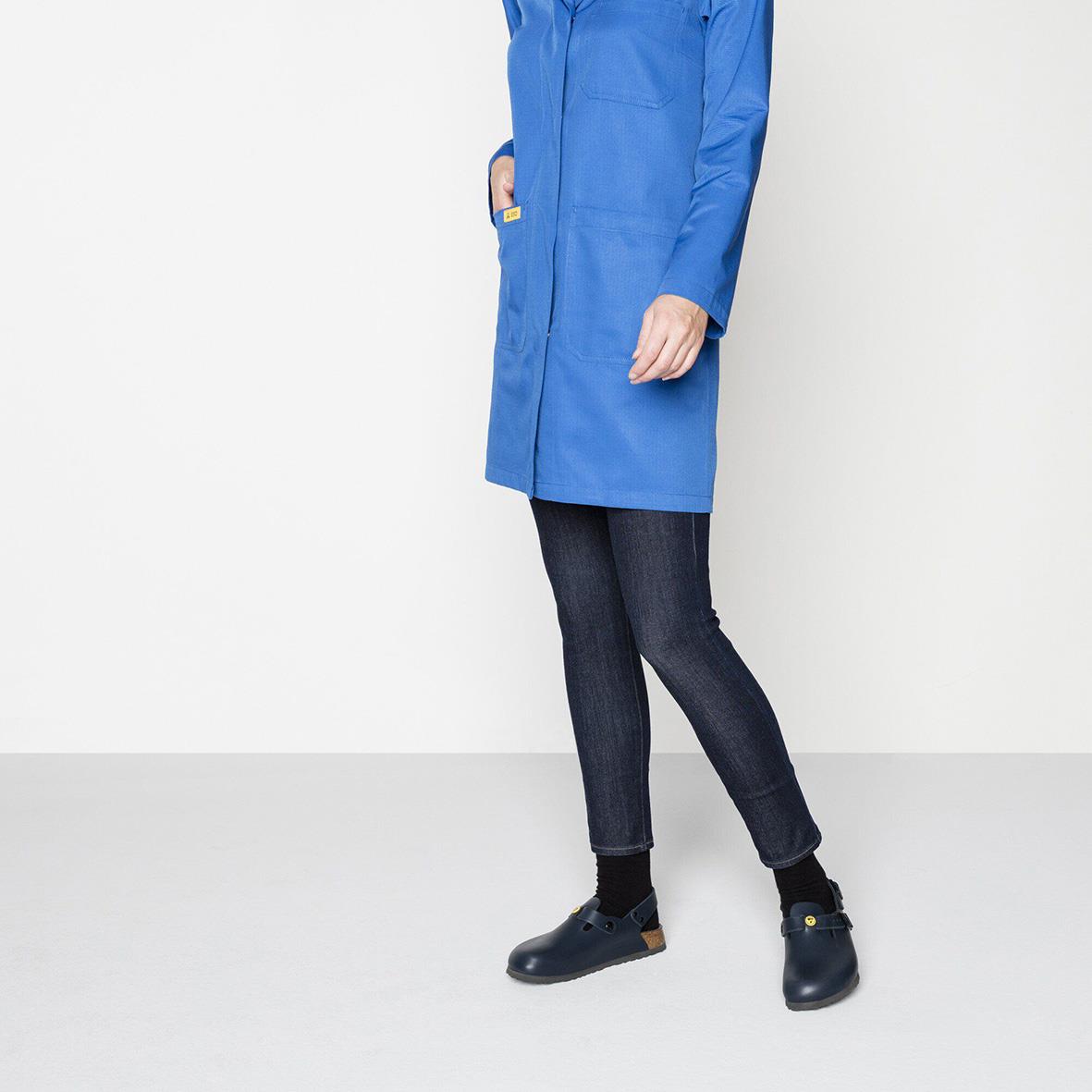 Person i blå jacka, mörka jeans och svarta Birkenstock Tokio ESD sandaler