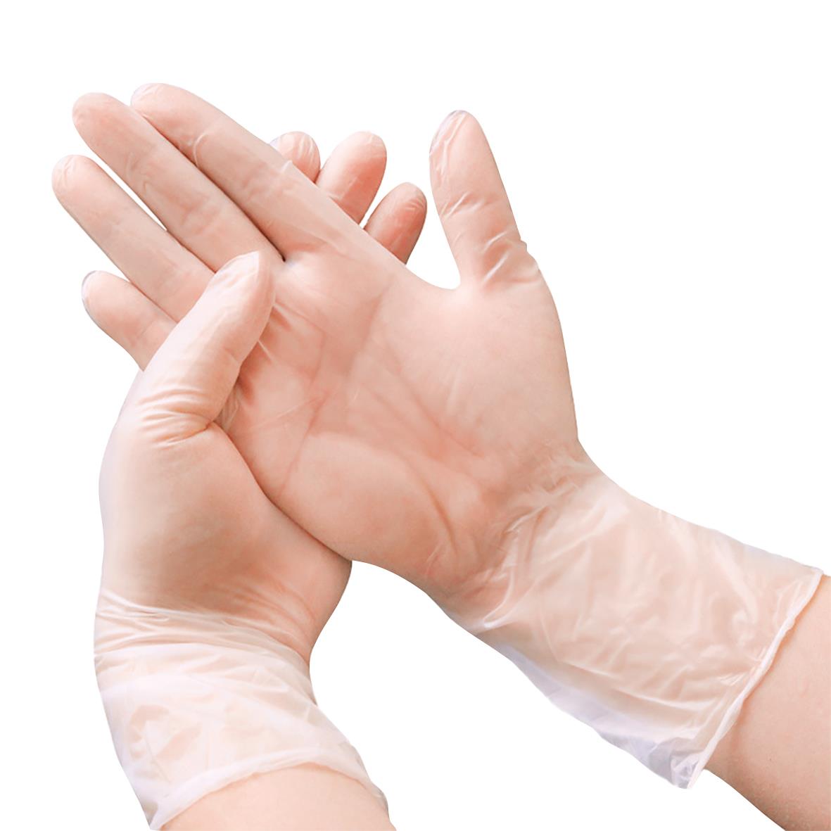 En person sätter på en vit vinyl engångshandske i storlek XL