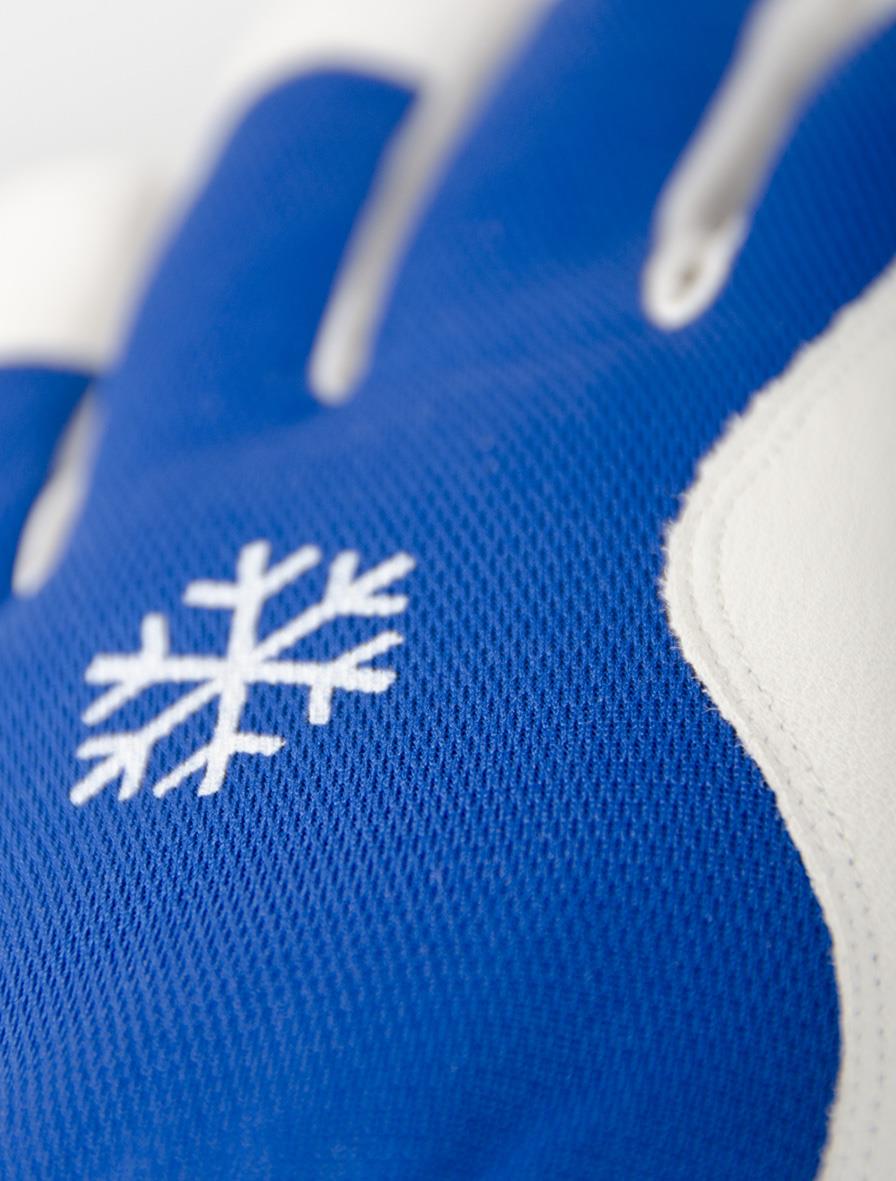 Närbild av en blå och vit Tegera 217-handskar med snöflingemotiv