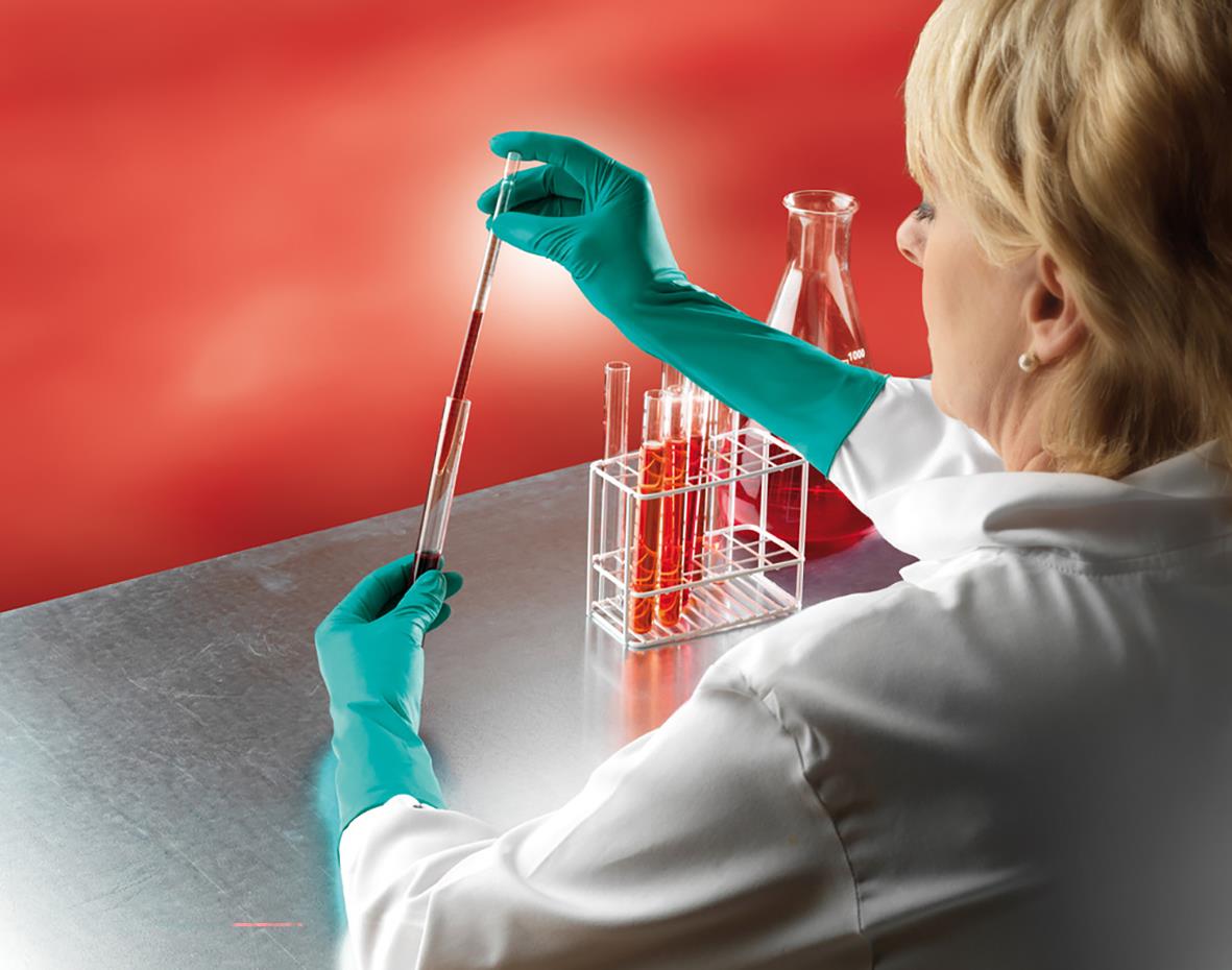 Person i labb använder nitrilhandskar och pipetterar i ett laboratorium