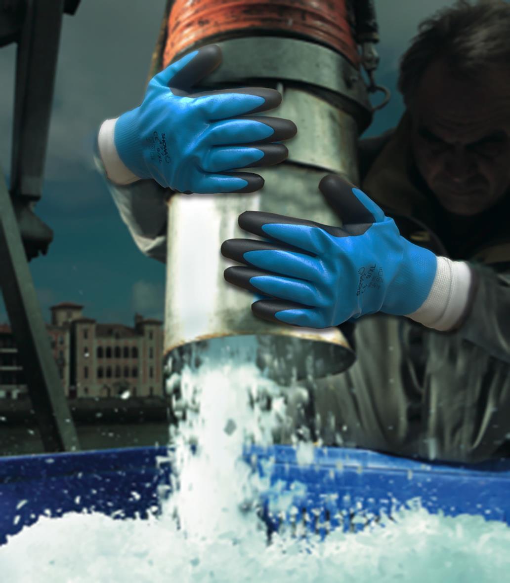 Person som använder blå och svarta nitrilhandskar för att hantera ett metallrör i en industriell miljö