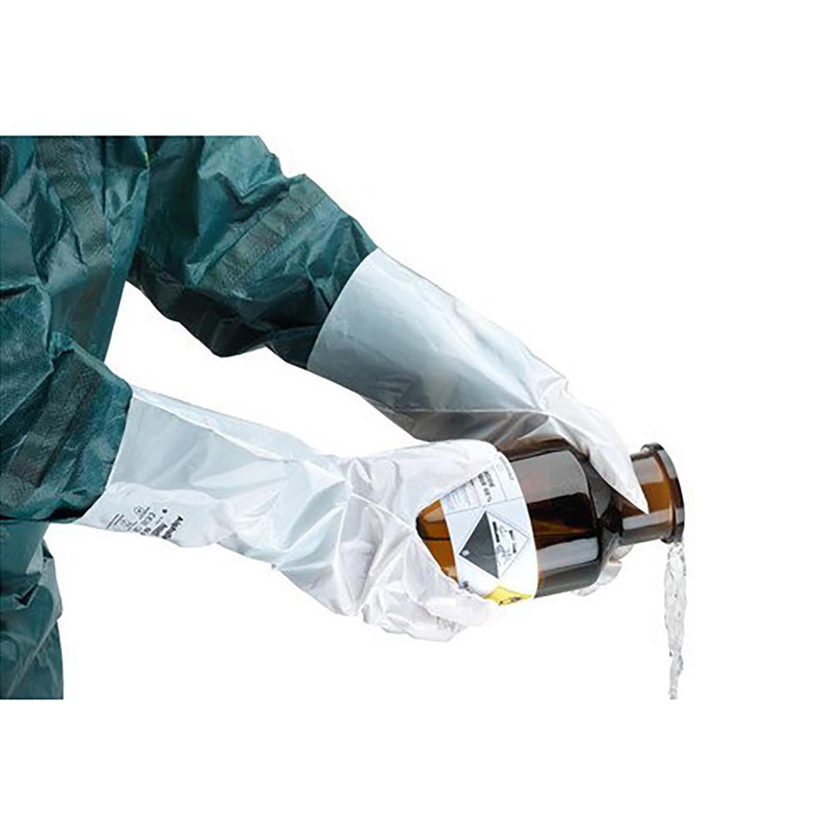 Person som bär vita kemskyddshandskar AlphaTec Barrier 02-100 och hanterar en vätskefylld flaska