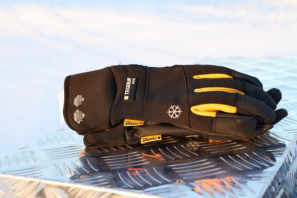 Vinterhandske Tegera 9130 svart med gula detaljer och snöflingemärke liggande på metallyta