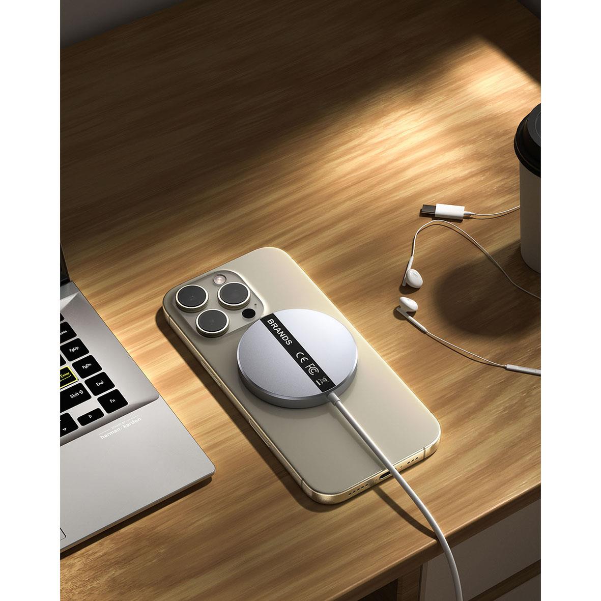 Trådlös Qi2 snabbladdare på mobiltelefon med hörlurar och laptop på träbord