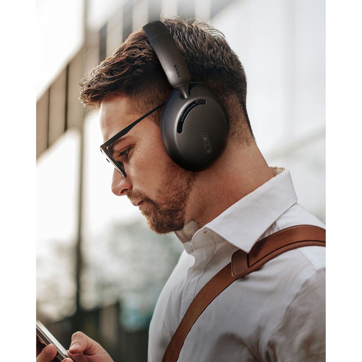 Man med svart trådlöst hörlurar Mixx Over-Ear StreamQ D3 ANC Svart, använder mobiltelefon