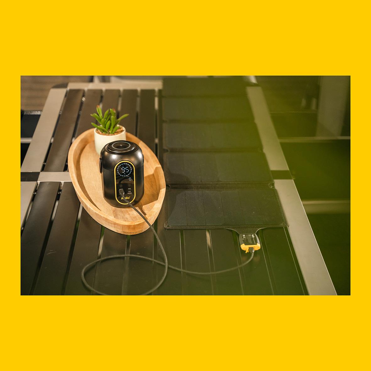 Powerstation Aqiila Powerbird S140 på svart bord med växt och liten skål