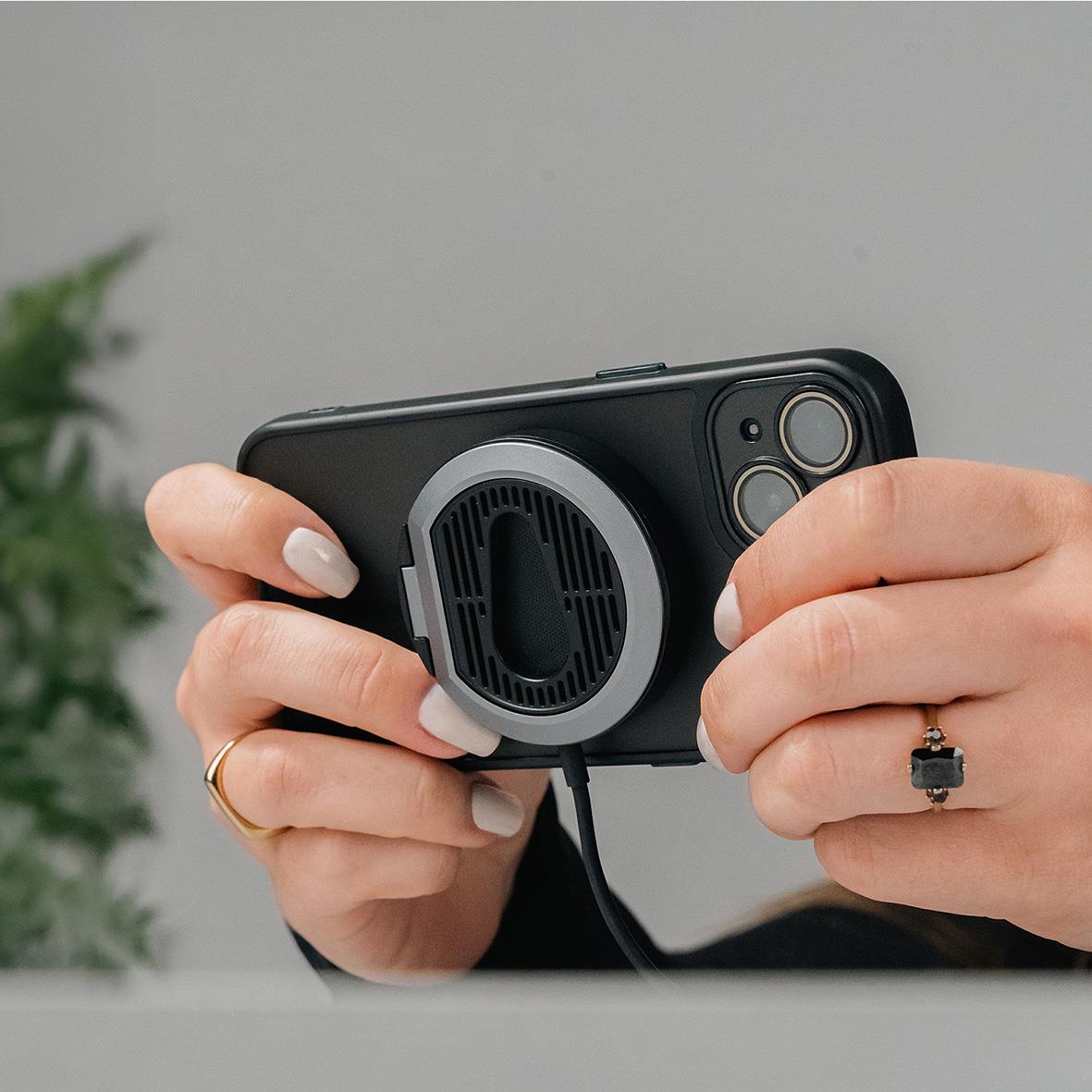 Trådlös mobilladdare Aqiila Qi2 15W med bilfäste, person håller telefon