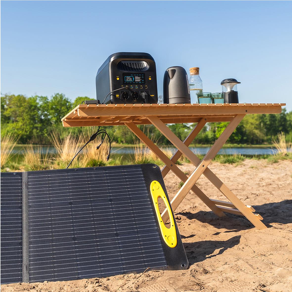 Powerstation Aqiila Powebird S1800V2 1800W på stranden med solcellspanel och bord