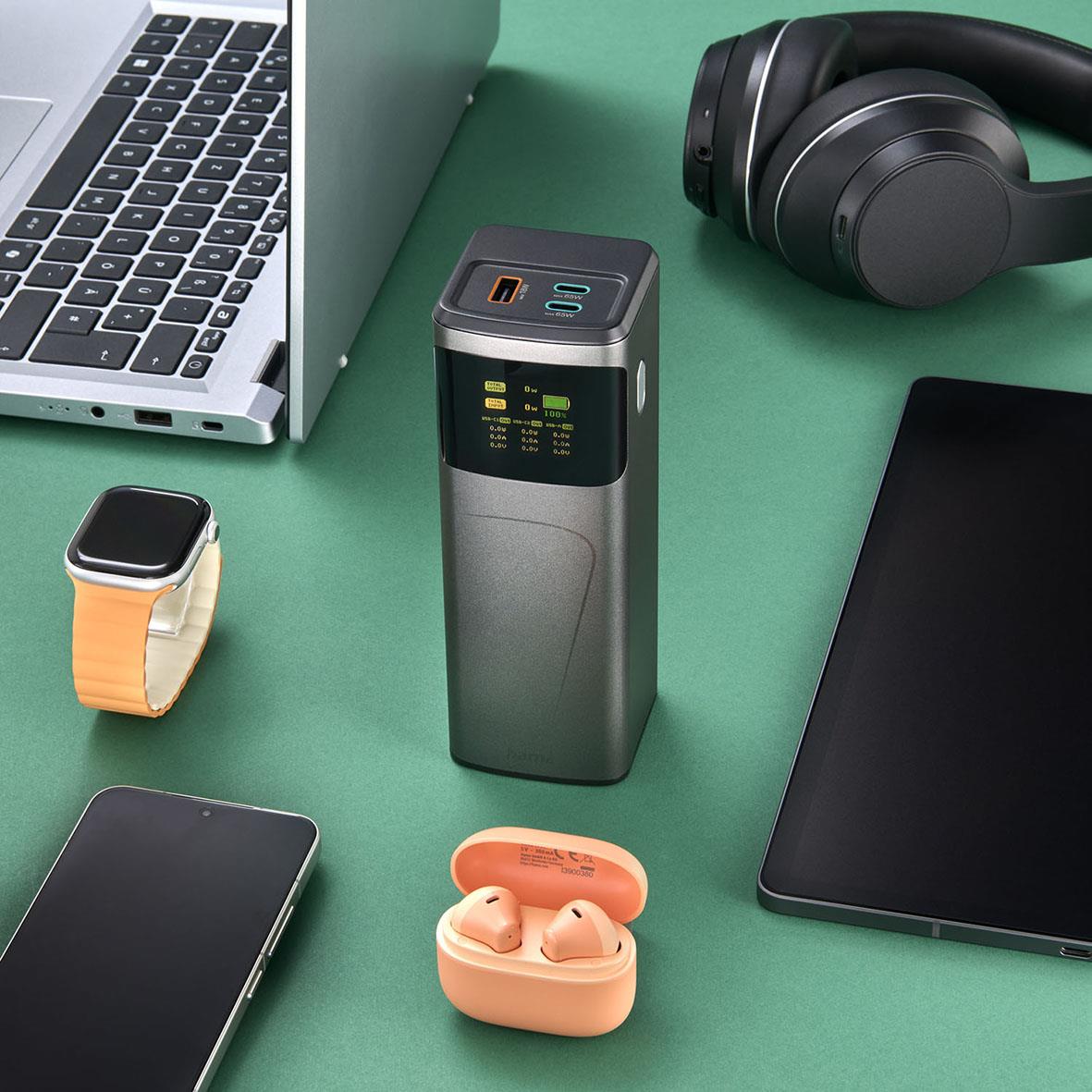 Dator, hörlurar, smartwatch, powerbank, smartphone, trådlösa hörlurar i ett grönt bord