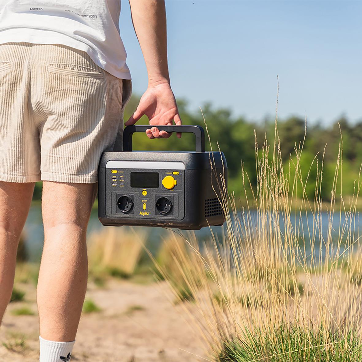 Person som bär Powerstation Aqiila Powerbird S1000v2 1000W 614Wh vid vattnet i naturen