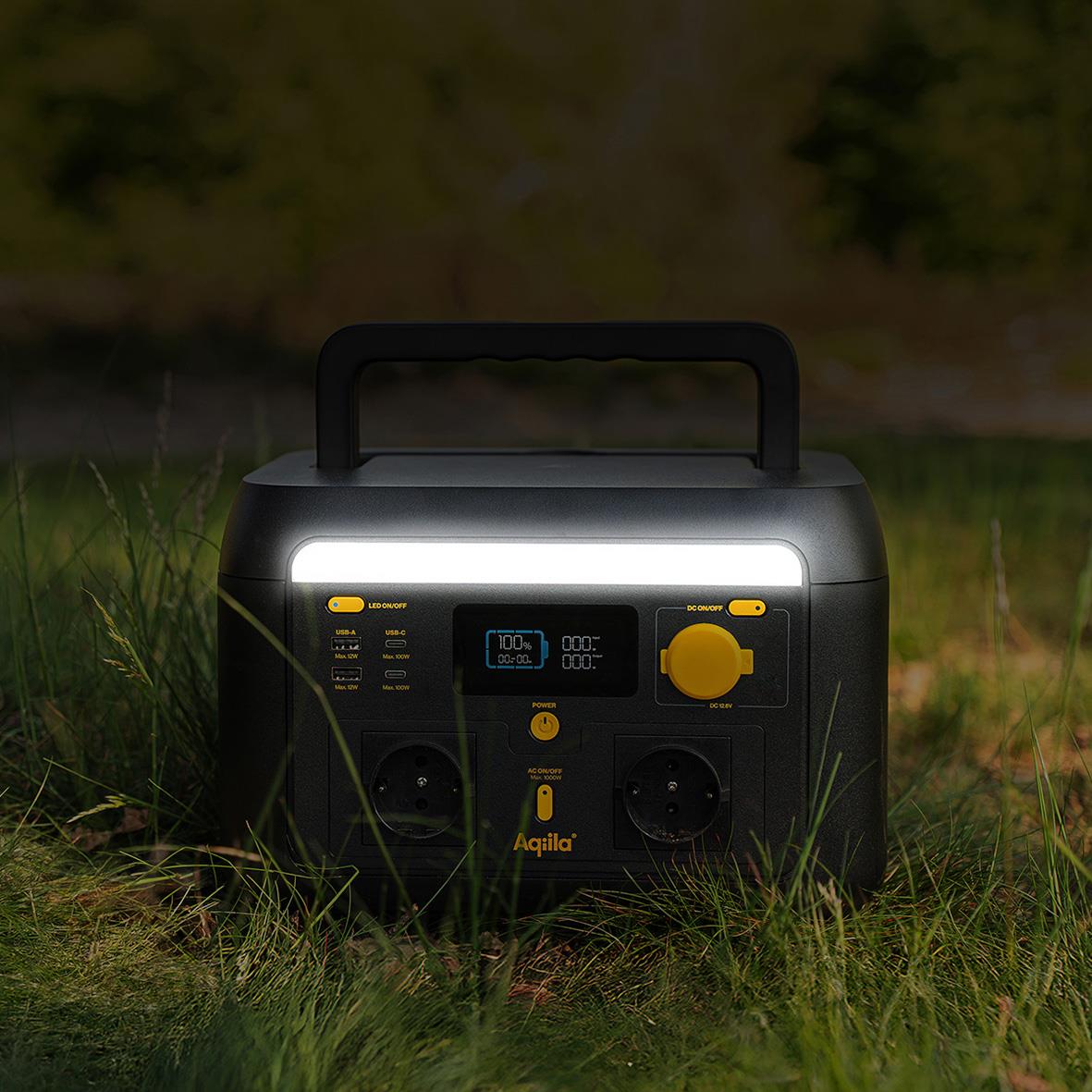 Powerstation Aqiila Powerbird S1000v2 1000W 614Wh på gräs med bakgrund av träd och natur