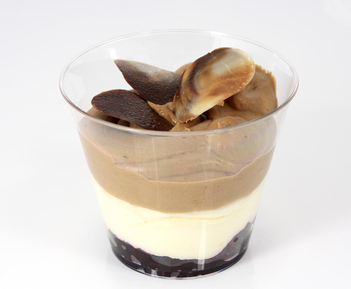 Klar dessertbägare med flera lager av choklad, vanilj och bär, toppad med chokladdekorationer