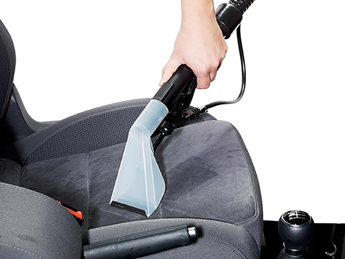 Person använder Matt- & Möbeltvätt Numatic CT370 för att rengöra en bilstol med en blå handhållen maskin