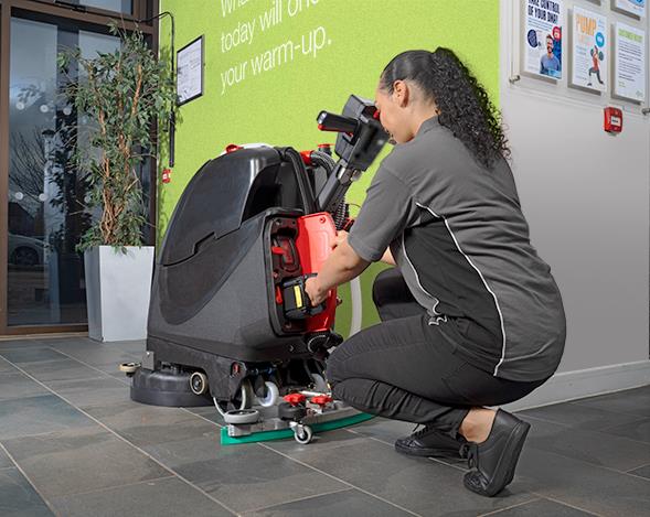 Kvinna som justerar en kombiskurmaskin Numatic TTB3045NXUB 450mm exkl batteri på golvet inomhus